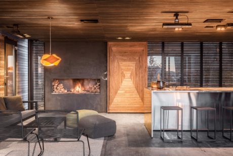 Warm, modern interior with wood accents, fireplace, and sleek kitchen design.