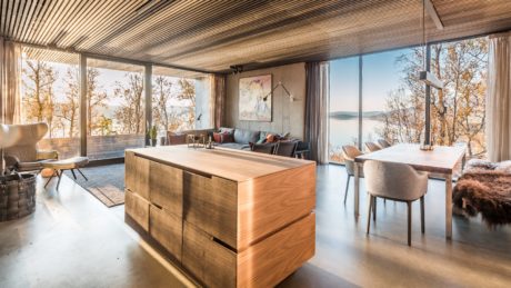 Stunning modern rustic interior with large windows, wood details, and a view.