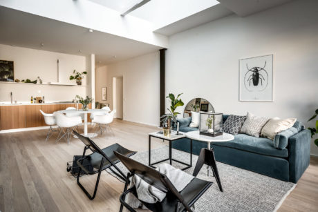 Modern open-plan living area with kitchen, dining, and seating spaces featuring sleek furnishings.