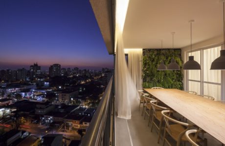 Elegant indoor dining area with verdant living wall and panoramic city views.