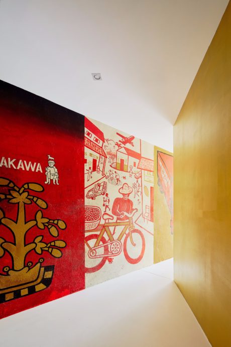 Vibrant red and yellow walls adorned with whimsical illustrations, creating an engaging interior.