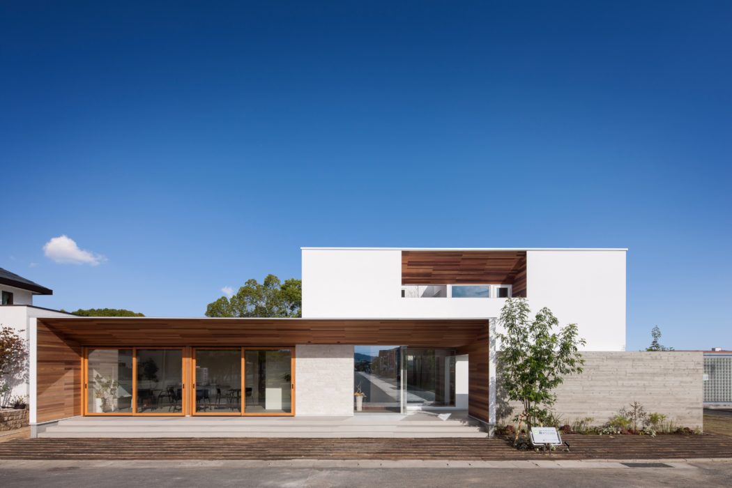 A modern, single-story home with large glass windows, wooden accents, and an open floor plan.