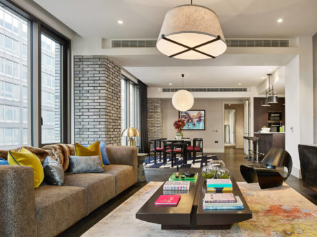 Modern living room with stylish furniture and large windows.