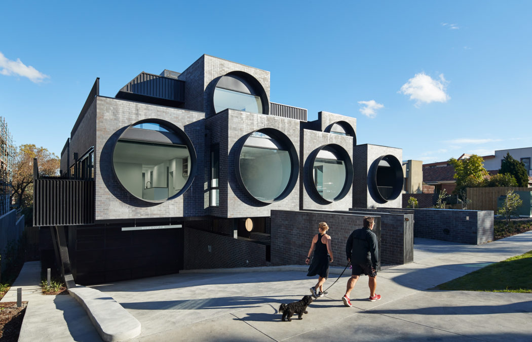 A striking, modern building with circular windows and unique architectural elements.