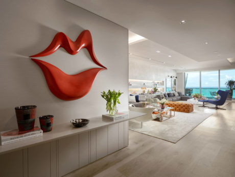 Spacious, modern living room with red sculpture, built-in cabinets, and panoramic ocean view.