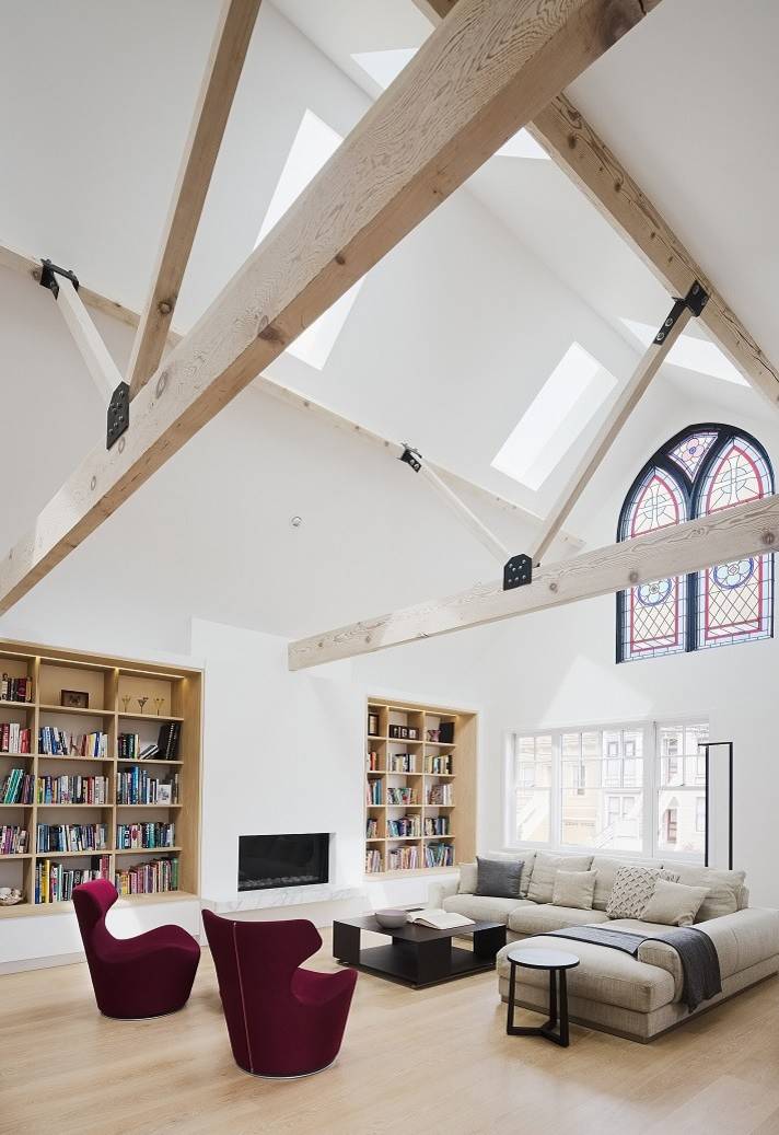 Bright living space with exposed beams and stained glass.