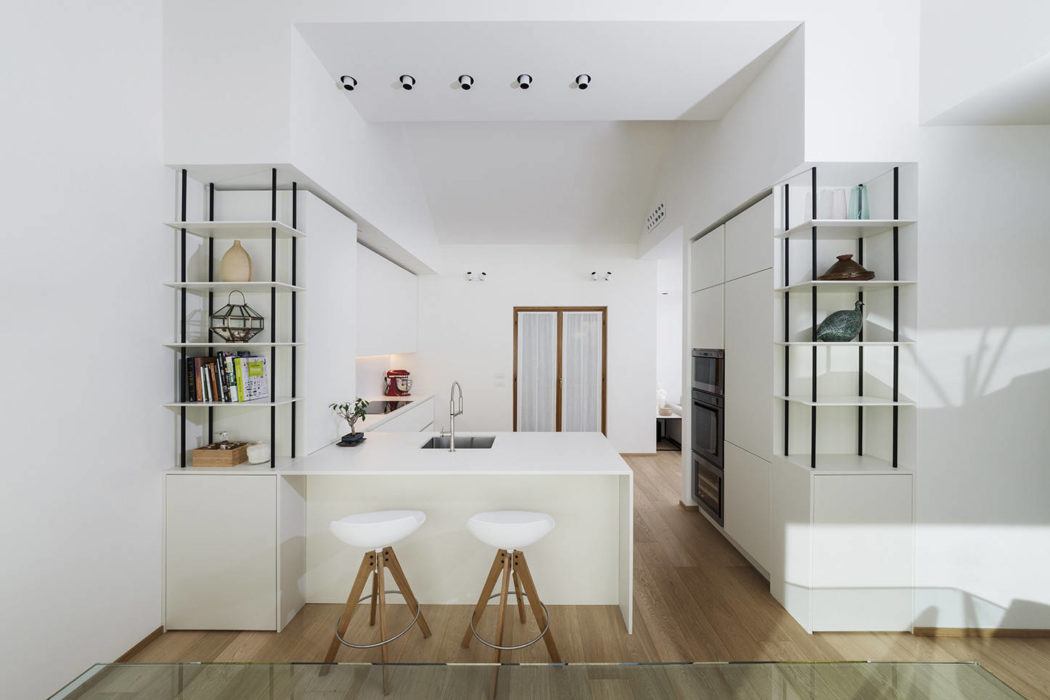 Bright, minimalist kitchen with modern shelving, island, and wood accents.
