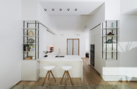 Bright, minimalist kitchen with modern shelving, island, and wood accents.