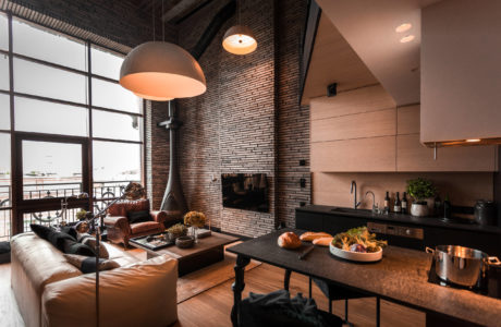 Impressive industrial-style space with exposed brick walls, modern lighting, and open kitchen.