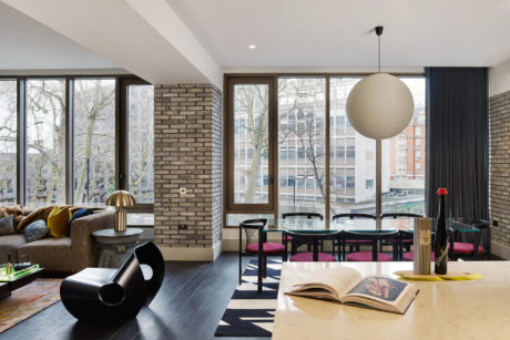 Chic living room with large windows and eclectic furniture.