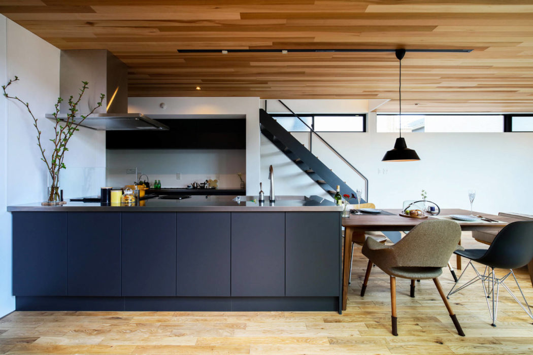Contemporary kitchen with wooden ceiling and herringbone floor.