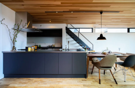 Contemporary kitchen with wooden ceiling and herringbone floor.