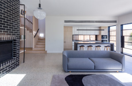 Contemporary open-plan living space with a staircase and a fireplace.