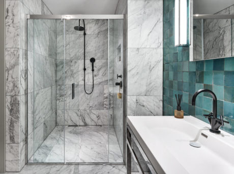 Elegant bathroom with marble walls and teal tiles.