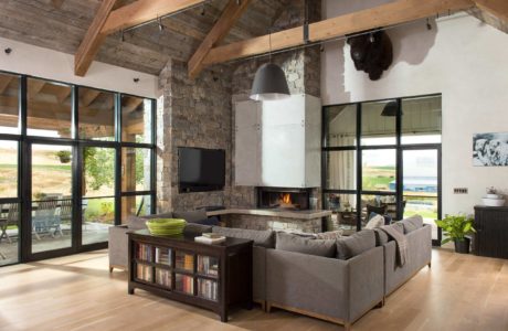 Spacious living room with fireplace, wooden beams, and large windows.