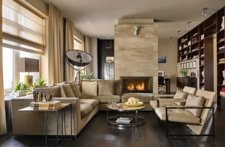 A cozy living room with a fireplace, sectional sofa, and built-in shelving showcasing decor.