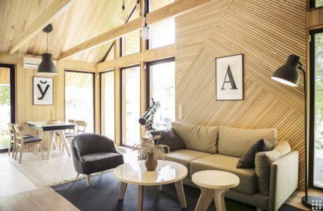 Warm, rustic interior with soaring wooden beams, cozy furniture, and sleek minimalist decor.