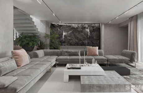 Minimalist living room with gray sectional sofa, concrete coffee table, and stone accent wall.