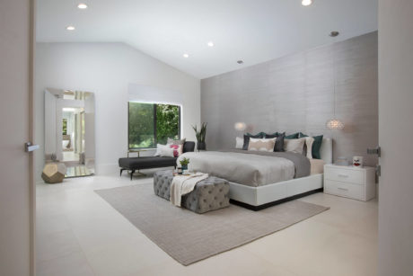 Spacious modern bedroom with clean, minimalist design and large window overlooking nature.