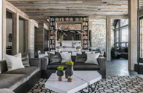 Rustic-chic living room with stone wall and bookshelf-divider.