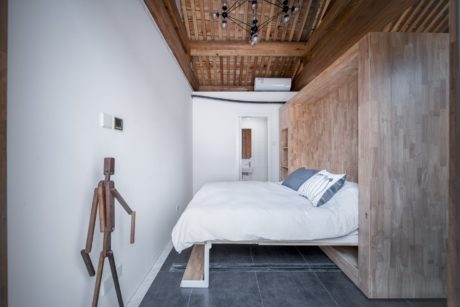 Warm wood tones, modern furnishings, and a cozy, minimalist bedroom design.