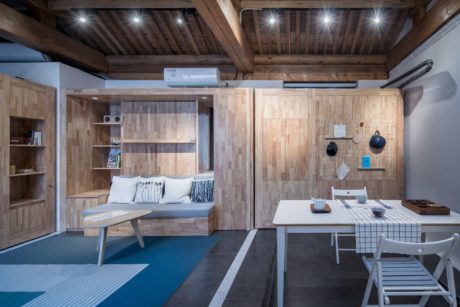 A cozy, rustic-style studio apartment with wooden paneling, modern furnishings, and a functional layout.
