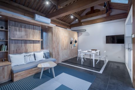 A cozy, rustic living space with wooden walls, exposed beams, and modern furnishings.