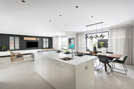 Spacious open-plan living area with kitchen island and geometric light fixtures.