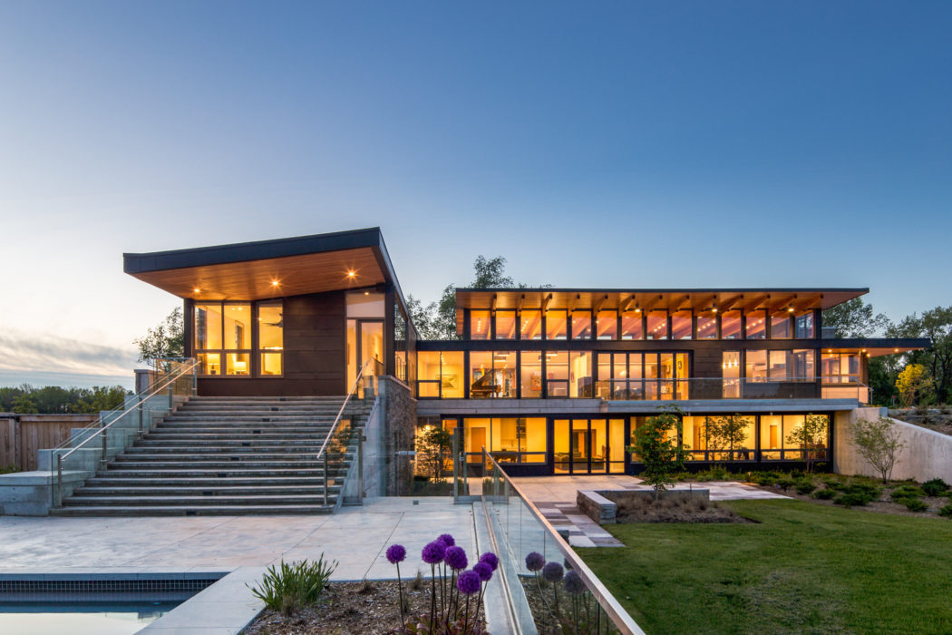 Striking modern architecture with sweeping glass walls and outdoor gardens.