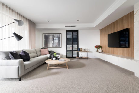Modern living room with neutral tones, sectional sofa, and wooden accents.
