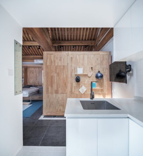 A compact space with a wooden ceiling, peg board, and modern sink. Efficient layout.