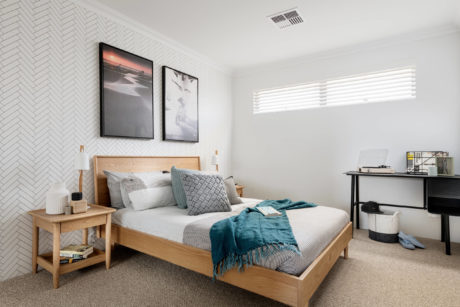 Contemporary bedroom with herringbone accent wall, framed art, and minimal decor