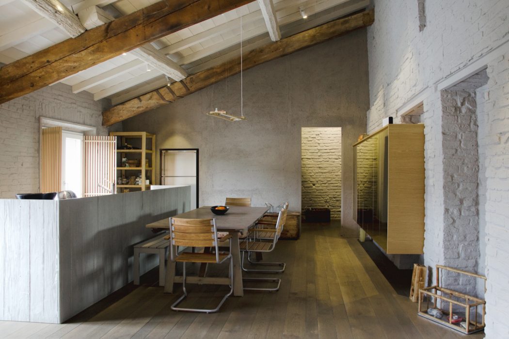 Modern rustic kitchen interior with dining area, wooden beams, and exposed brick.