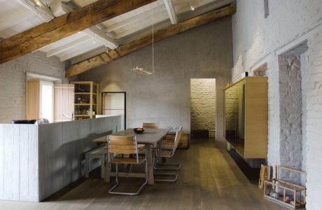 Modern rustic kitchen interior with dining area, wooden beams, and exposed brick.