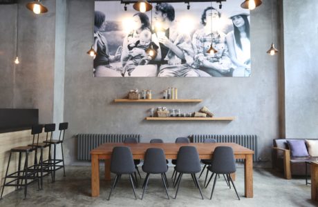 Contemporary dining area with concrete walls and large photo decor.