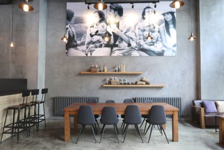 Contemporary dining area with concrete walls and large photo decor.