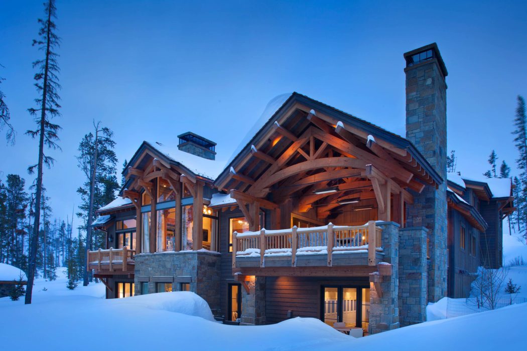 Luxe timber lodge surrounded by snow at twilight