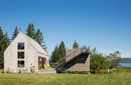 Contemporary dual-structure home with unique roofs and seaside view.