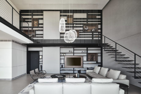 Modern living room with mezzanine, staircase, and minimalist decor.