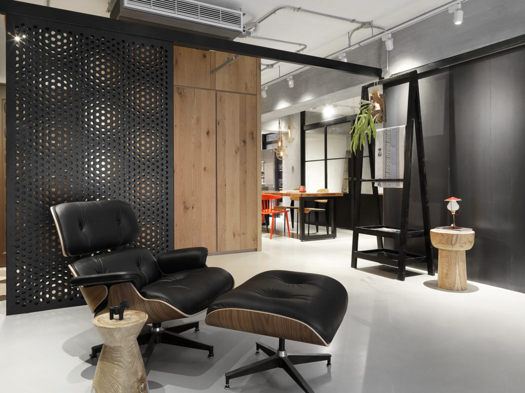 Modern office lounge with black Eames chair and wooden accents.
