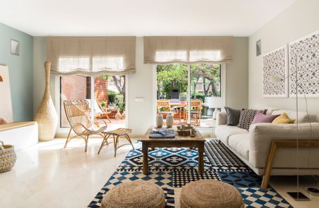 Contemporary living room with patterned rug and garden view.