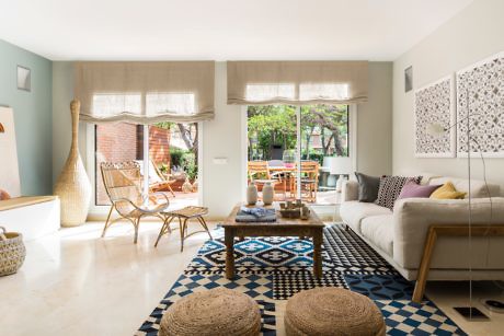 Contemporary living room with patterned rug and garden view.