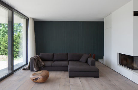 Contemporary living room with dark sectional sofa and fireplace.