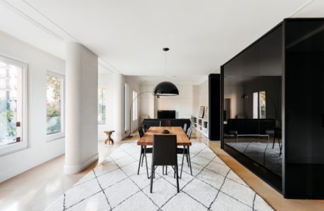 Contemporary dining space with monochrome accents and large windows.