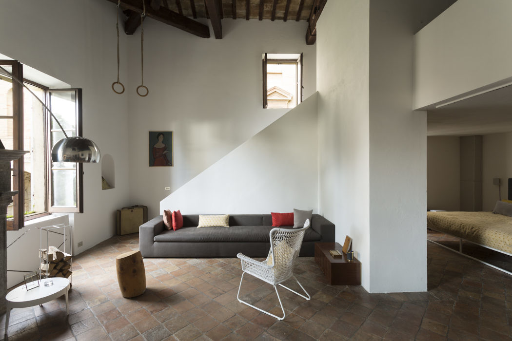 Contemporary living space with exposed beams and terracotta flooring.