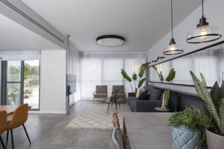 Contemporary living room with sleek furniture and pendant lights.