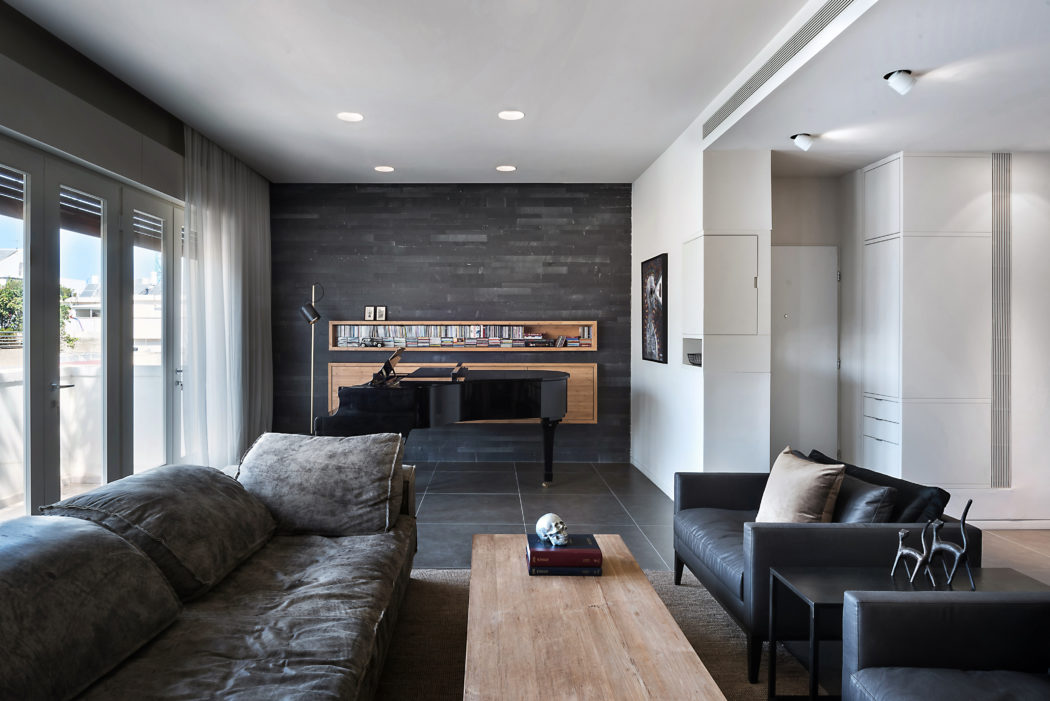 Contemporary living room with gray tones, piano, and plush seating.
