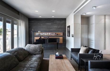 Contemporary living room with gray tones, piano, and plush seating.