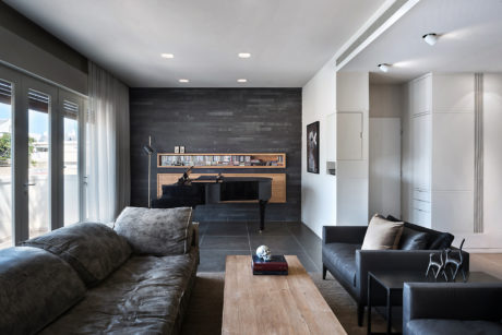 Contemporary living room with gray tones, piano, and plush seating.