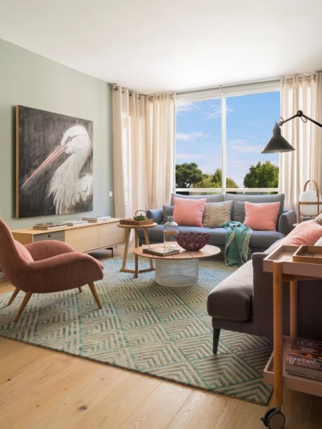 Contemporary living room with pastel accents and bird artwork.